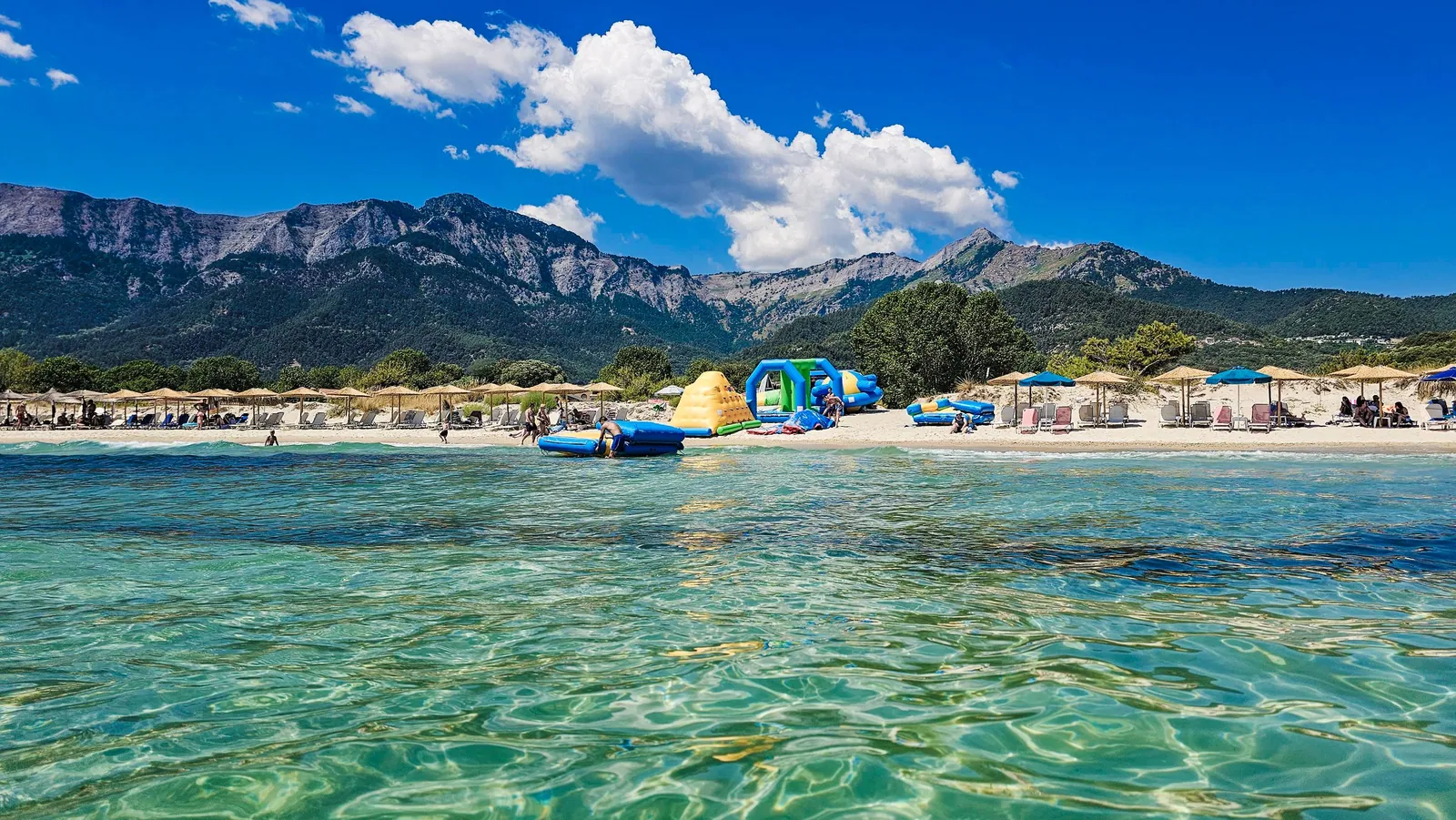 Golden Beach on Thassos with clear shallow water, pale sand, and Mount Ipsarion behind it